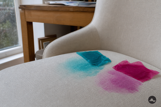 Nat turquoise en magenta crêpepapier geeft kleur af op een ivoren bank