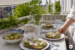 Skandinavisk forårsfrokost med rugbrød og krydret kartoffelsalat på en solrig altan