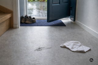 Segno nero di scarpa su un pavimento in PVC grigio chiaro all'ingresso