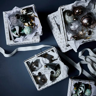House Doctor kerstballen en hangornamenten in open doosjes op een donkere ondergrond