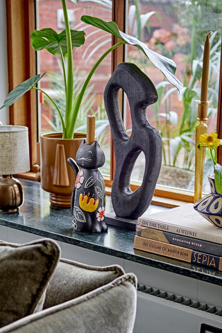 Sfeervol interieur met kleurrijke vazen, kandelaars en sculpturen van Bloomingville
