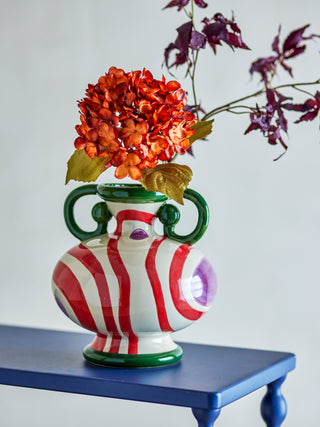 Betiva vaas met oranje en paarse bloemen op een blauwe tafel