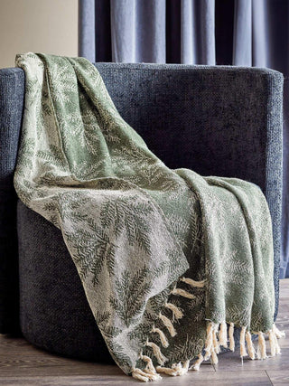 Groene Gabriela plaid met varenpatroon over een fauteuil