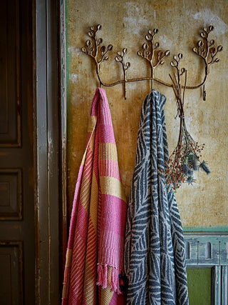 Roze Isnel plaid hangend aan een decoratieve kapstok