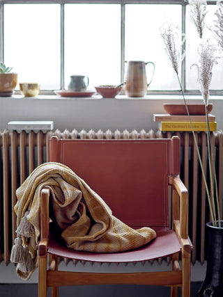 Lounge chair leer bruin Ollie van Bloomingville, gepresenteerd in een natuurlijke buitenomgeving