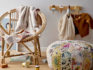 Aranya kledinghanger rattan naturel van Bloomingville Mini, gepresenteerd in een natuurlijke buitenomgeving