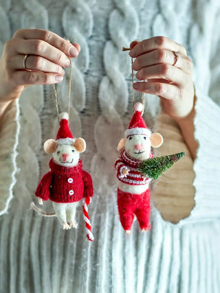 Twee rode Peo kerstmuisjes hangend in een hand