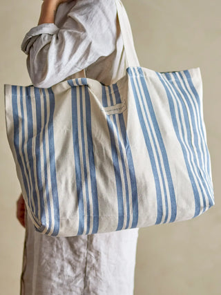 Shopper katoen blauw Trina van Bloomingville, gedragen met formaat en hengsels duidelijk zichtbaar