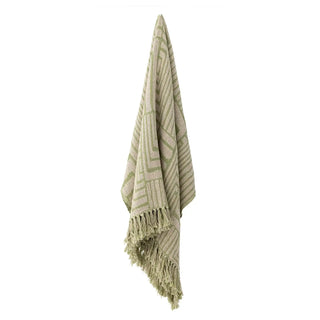 Groene Velva plaid hangend tegen een witte achtergrond