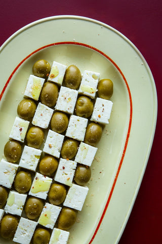 Feta en groene olijven met chilivlokken op een schaal