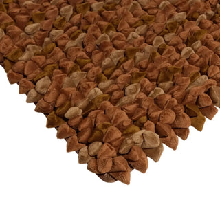 Pebble kleed 65x95cm Rustic bronze van Haans Lifestyle, toegepast op een stoel of bank in een interieursetting