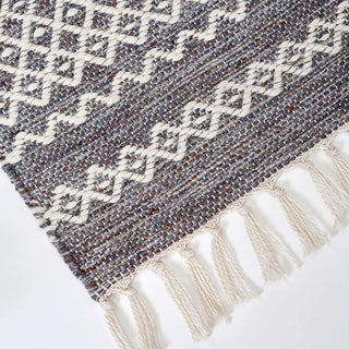 Detail van buitenkleed Ciero met geometrisch weefpatroon en geknoopte franjes langs de rand