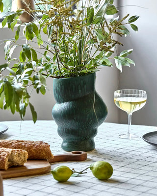 Groene vaas Disc 25cm van House Doctor, toegepast in een sfeervolle interieursetting