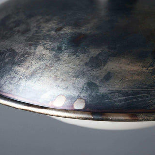 Donkere metalen lampenkap met getextureerde, geschilderde afwerking en zichtbare rand