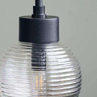 Detail van hanglamp Gaia met zwarte fitting, geribbelde glazen kap en zichtbare lichtbron