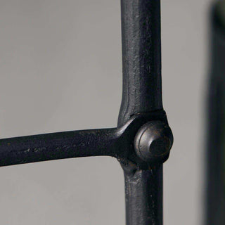 Zwart metalen frame met ronde knopdetails en matte afwerking