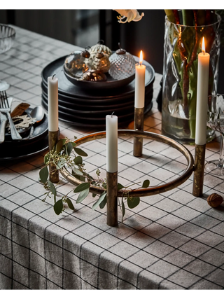 Kandelaar Maxi Advent antiek koper 30cm van House Doctor, met vier dinerkaarsen en groen op een gedekte tafel