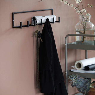 Zwart metalen wandhaak met jas, sleutels en krant, modern interieuraccessoire