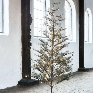 Kerstboom Pin natuur 220cm van House Doctor, toegepast in een sfeervolle interieursetting