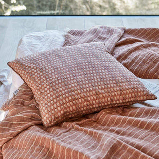 House Doctor Ayda kussenhoes met paisleydessin op een bed met gestreept beddengoed