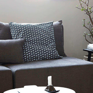 Kussenhoes Nero met licht bloemenpatroon, gestyled tussen effen kussens op een bank
