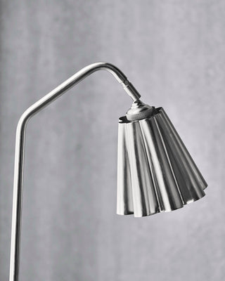 Lampenkap Flola geborsteld zilver Ø16×16 cm van House Doctor, geplaatst in een stijlvolle werk- of woonomgeving