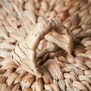 Natuurlijke rieten mand met gevlochten handvat, ideaal voor opbergen of decoratie in de woonkamer