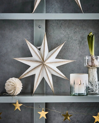 Papieren ster 9 punten champagne 30cm van House Doctor, staand op een wandplank tussen winterse decoraties
