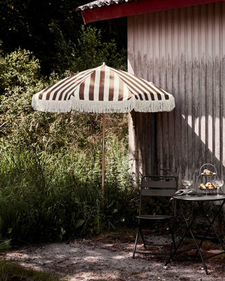 Parasol Shade bruin 190cm van House Doctor, toegepast in een sfeervolle buitenomgeving