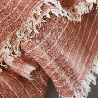 Close-up van roestroze gestreepte plaid Alice met geweven structuur en franjes