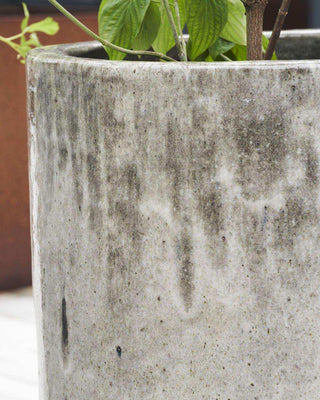 Detail van Pot Pho met brede rand, donker gevlekt oppervlak en plantstelen met groen blad