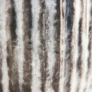 Detail van verticale ribbels met een licht en donker verweerde bruin-grijze afwerking