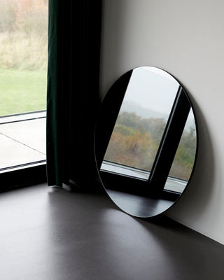 House Doctor ronde spiegel Walls grijs van 80 cm leunend bij een raam