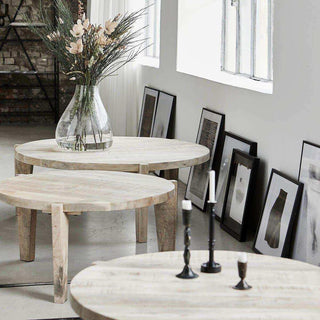 Drie ronde salontafels Bali in een licht interieur, gestyled met bloemenvaas en kandelaars