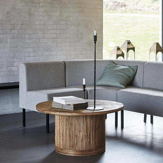 Ronde salontafel Gro met boeken en kandelaars voor een grijze hoekbank