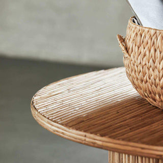 Detail van het ronde blad van salontafel Gro met parallelle stokken en een gevlochten mand
