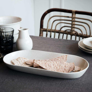 Witte Pion serveerschaal met stukken platbrood op een gedekte tafel
