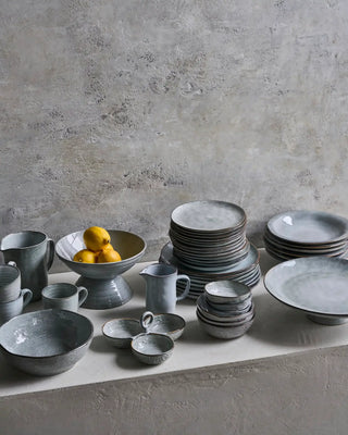 Rustic grijsblauw servies met gestapelde soepborden en ander tafelgerei