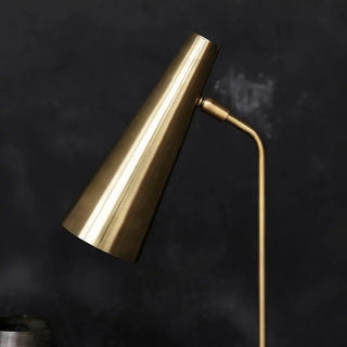 Detail van messingkleurige tafellamp met conische kap, scharnier en gebogen arm