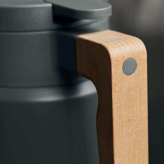 Close-up van groene thermoskan Cole met houten handgreep en ronde bevestiging