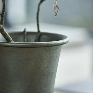 Detail van de opstaande rand van vaas Florist met takken in de opening