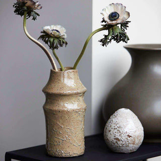 Nature vaas met drie bloemen, naast een donkere vaas en een decoratief object