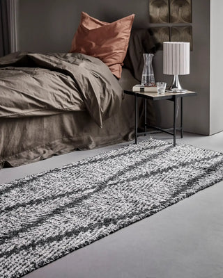 Vloerkleed Kin zwart gebroken wit 90x200 cm van House Doctor, toegepast in een sfeervolle interieursetting