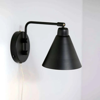 House Doctor Game wandlamp aan een lichte muur, met gebogen arm en conische kap