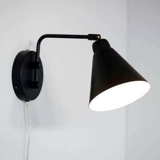 House Doctor Game wandlamp ingeschakeld, met gebogen arm en helder verlichte kap