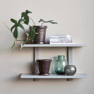 Grijs Sheo wandrek met twee planken, ingericht met een plant, boeken, potten en vazen