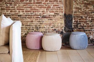 Coto Brus opbergpoefs van House of Nature in roze, zand en blauw in een interieur