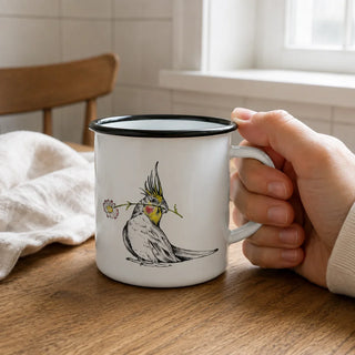 Ligarti emaille mok bloemenkuif – 300 ml van dichtbij in gebruik, met de illustratie en dunne zwarte emaille rand zichtbaar.