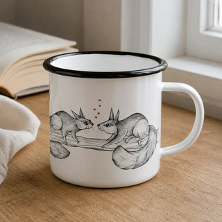 Ligarti emaille mok eekhoornduo – 300 ml van dichtbij in gebruik, met de illustratie en dunne zwarte emaille rand zichtbaar.