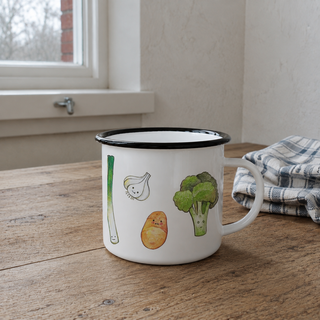 Ligarti emaille mok Groenten 300 ml op een houten keukentafel bij natuurlijk raamlicht.